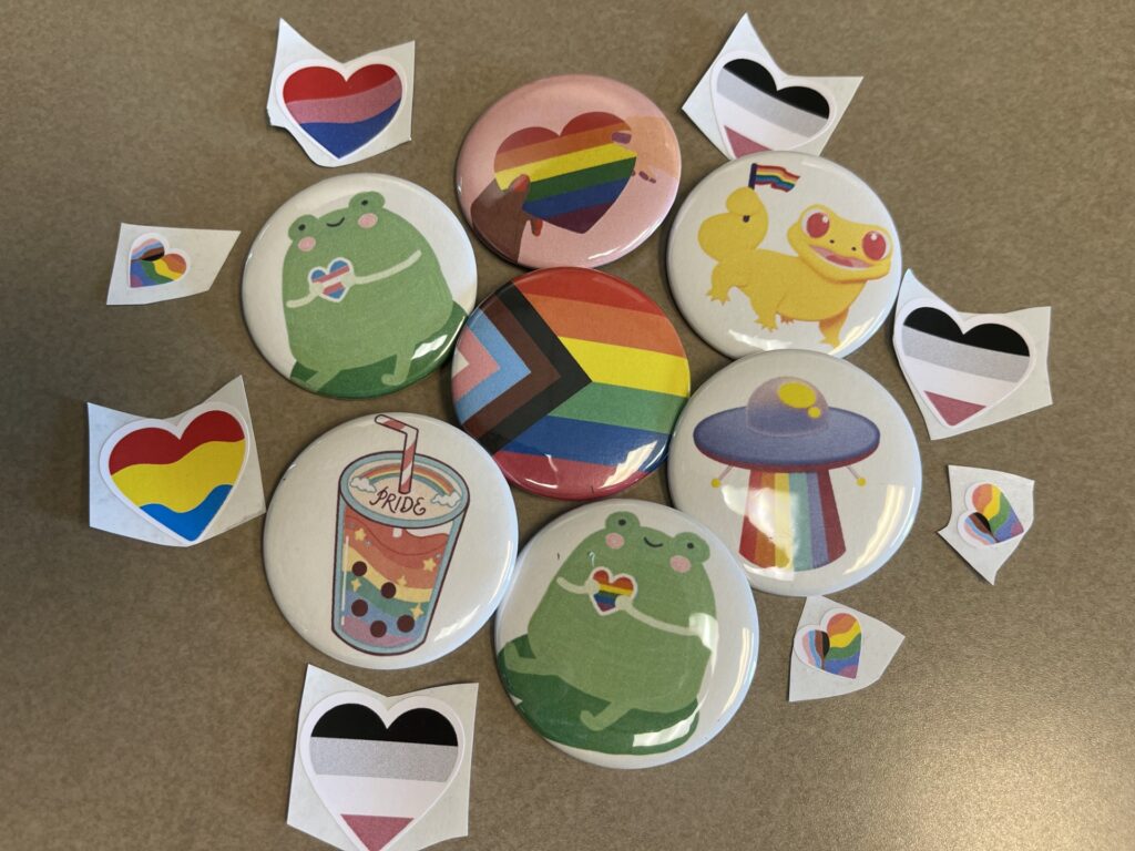 Seven Pride buttons and Eight Pride Stickers